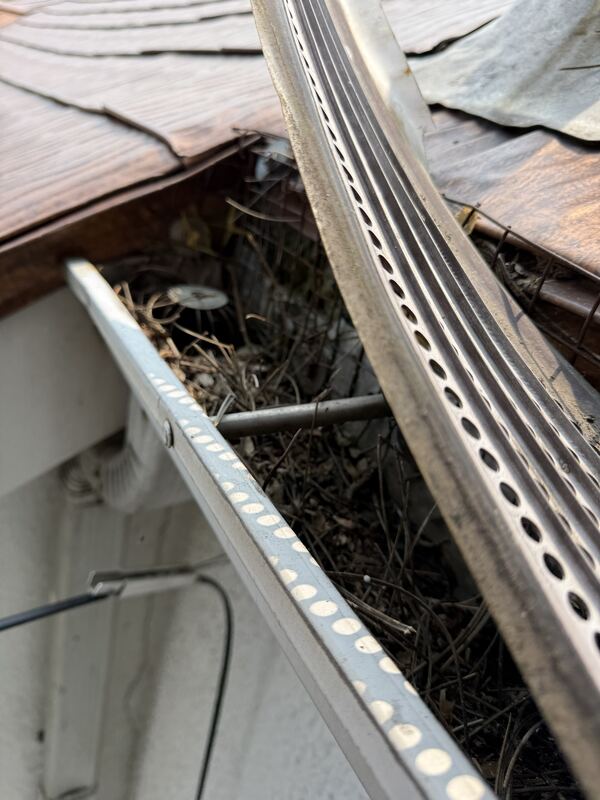 Crew fitting a perforated gutter guard over the gutter